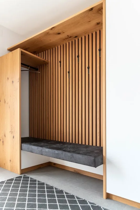 Hohe Garderobe mit Holzlamellen und Sitzbank